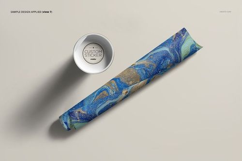 Top view of a packaging mockup featuring a mailing tube with swirling blue and gold design and a white lid nearby.
