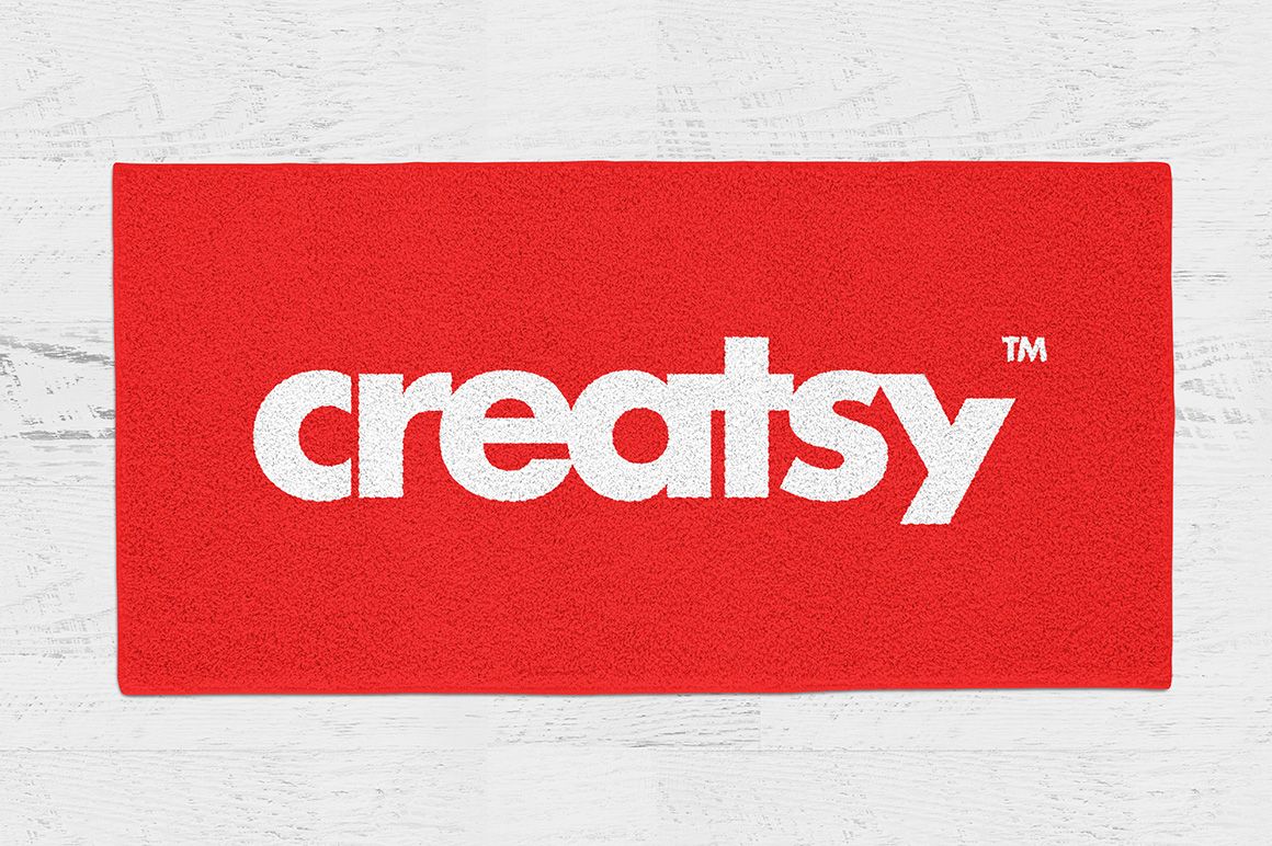 Red rectangular rug featuring large white lettering, displayed flat on a light wooden background in a PSD mockup.