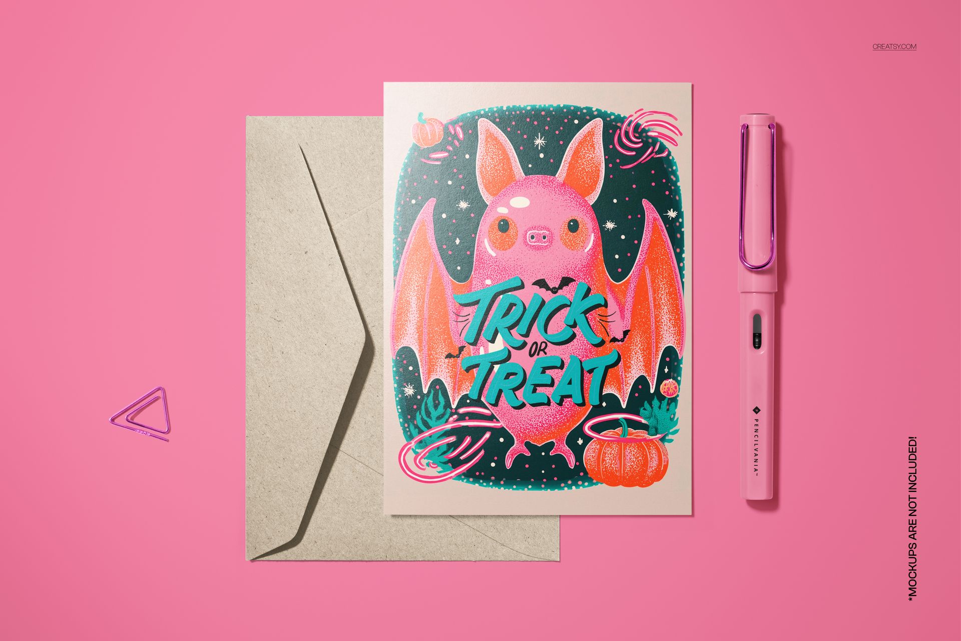 Halloween card mockup with a red bat, pumpkins, and candy, displayed next to a beige envelope on a pink background.