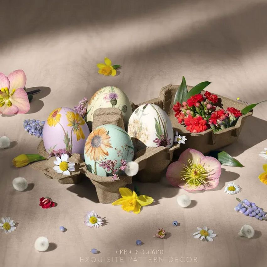 Egg carton mockup featuring decorated eggs with floral patterns, surrounded by assorted spring flowers on a neutral surface.