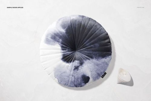 Mockup of a round velvet cushion with piping, black and white gradient pattern, placed on a marble-textured background.