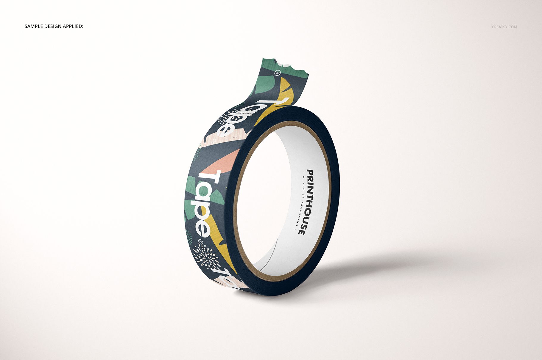 Mockup of a paper packing tape roll featuring multi-colored geometric design, displayed upright on a plain surface.