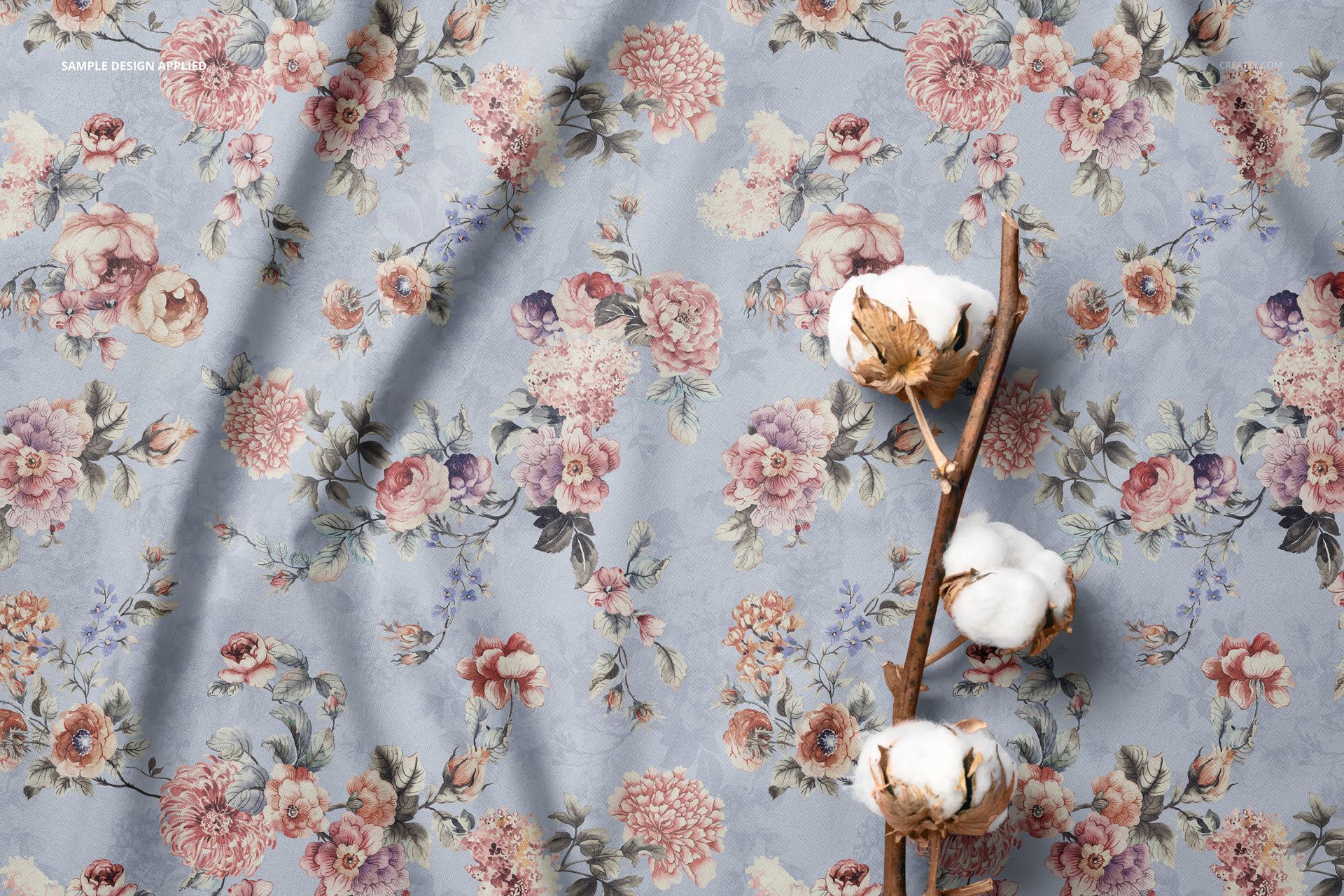 Fabric mockup featuring a cotton branch on a light blue surface with a detailed floral pattern in soft pastel colors.