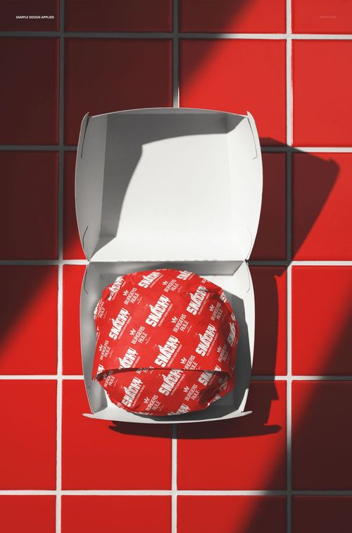 PSD mockup featuring a paper-wrapped burger in an open white box, positioned on a vibrant red tiled background.