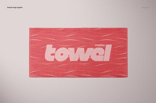 Rectangular towel mockup with a coral pink color, white wavy lines, and bold white text, shown from above.