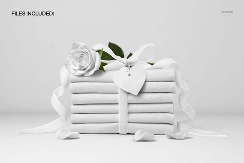 Front view of a fabric stack wrapped with a velvet ribbon, featuring a white rose and heart tag, PSD mockup scene.