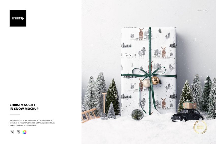 PSD mockup featuring a gift box with Christmas motifs, placed in a snowy scene with small trees and seasonal props.