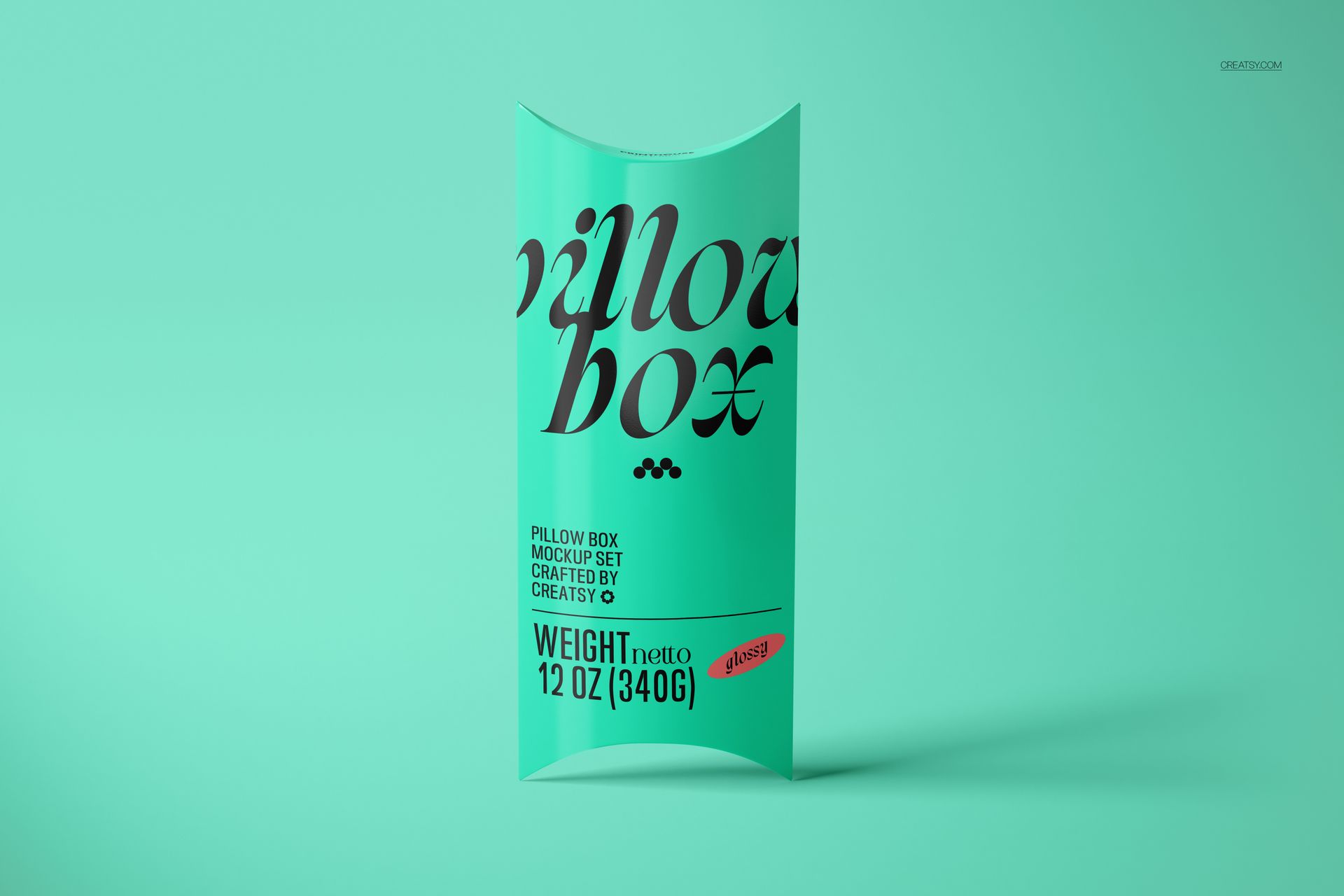 Turquoise pillow box mockup with large black lettering, displayed upright against a plain mint-colored backdrop.