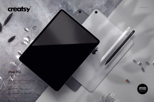 PSD mockup set featuring iPad Pro tablets and styluses, placed on a light surface with decorative leaves nearby.