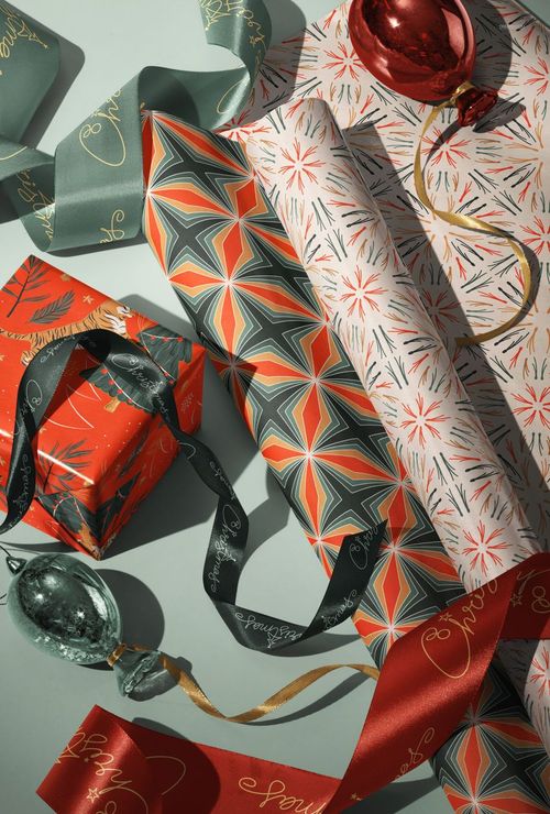 Christmas-themed PSD mockup showing a wrapped gift box, decorative ribbon, and festive ornaments from above.