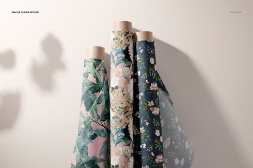 Fabric rolls mockup featuring botanical and floral designs in various colors, displayed upright against a neutral wall.