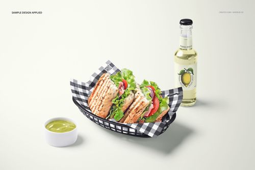 Mockup scene showing a sandwich in a black basket with food safe paper, next to a small bowl of sauce and a bottled drink.