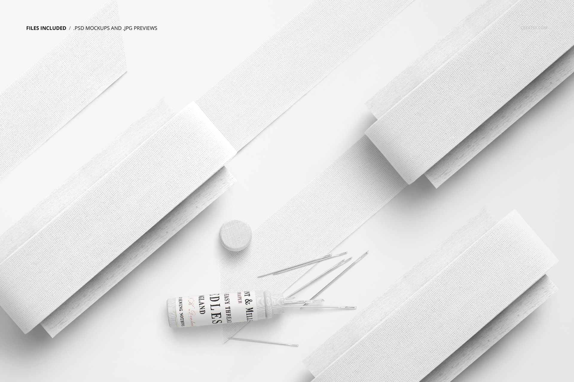 Top view of several white cotton ribbons arranged on flat paddles with a spool and scattered strips on a light surface.