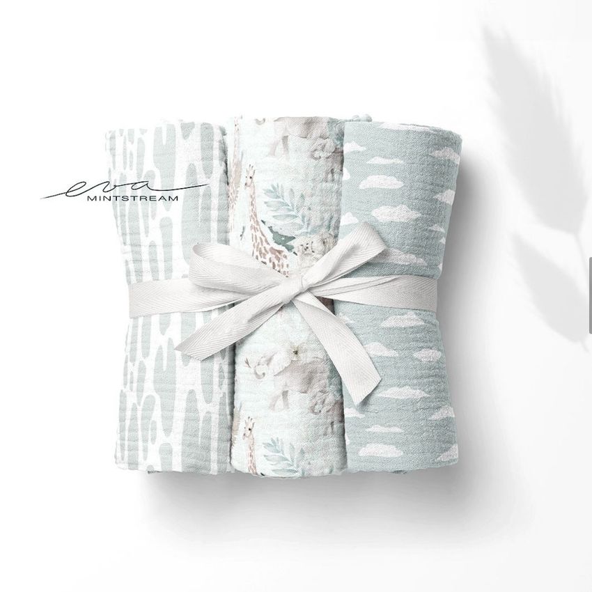 Crinkle muslin swaddle blanket mockup showing three folded blankets in soft blue and white patterns, tied with a ribbon.