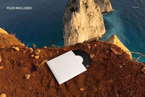 High angle view of a 7 inch black vinyl record mockup on brown earth near a steep seaside cliff and ocean.