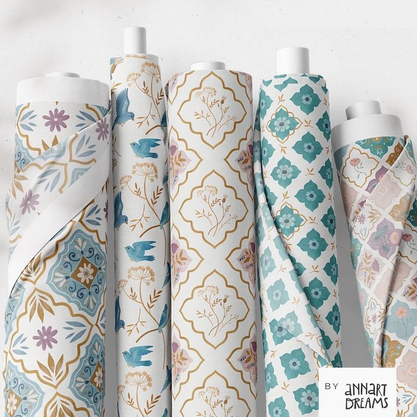 Fabric rolls mockup featuring five upright rolls with Moroccan-inspired floral and geometric patterns in blue, gold, and purple tones.
