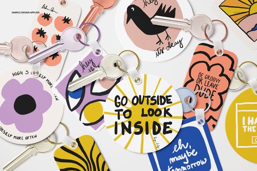 PSD mockup of multiple key tags with vibrant illustrations and phrases, arranged flat with keys in a scattered layout.