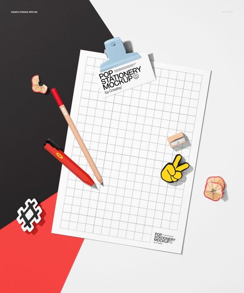Top view of a notepad poster mockup with grid pattern, surrounded by pencils, eraser, and paper clips on a color-blocked background.
