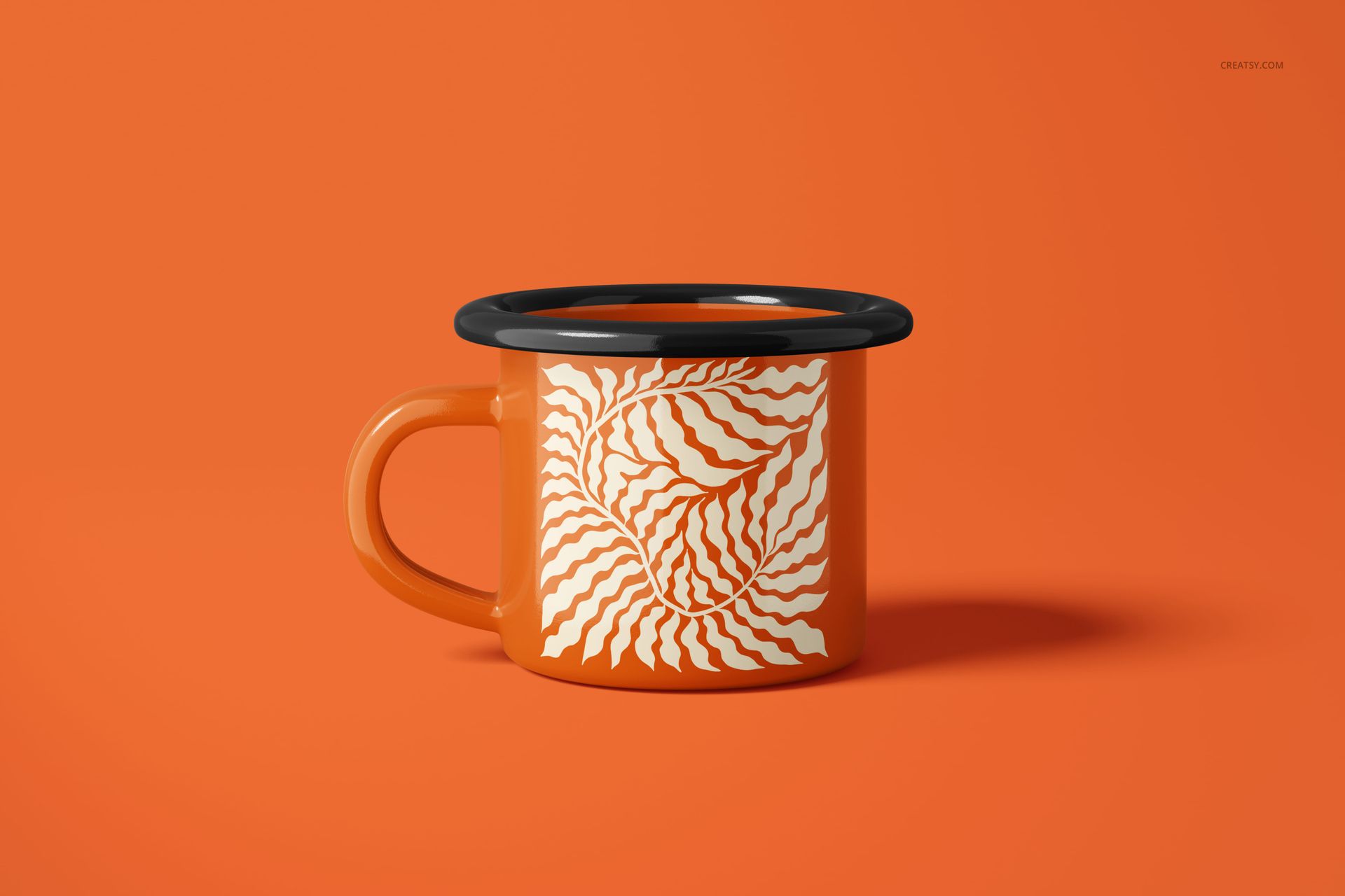 Orange enamel mug with a black rim and white abstract leaf pattern, displayed on a matching orange background, front view.