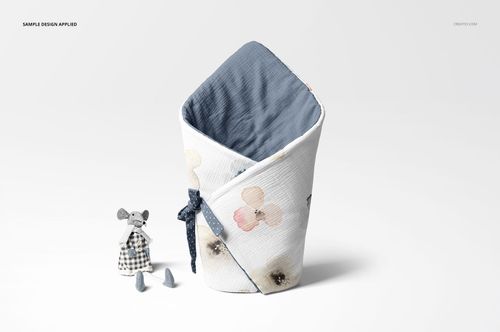 Newborn swaddle wrap mockup featuring a blue interior, light floral exterior, and a plush toy mouse beside it.