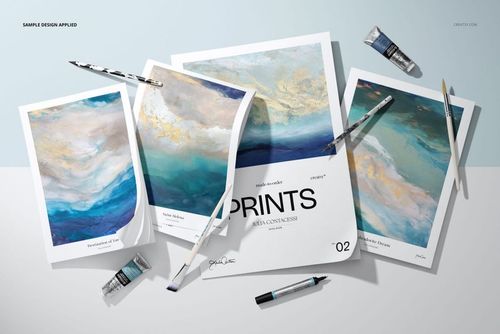 PSD mockup showing several art paper pads with blue and gold abstract designs, paint supplies scattered around on a white background.
