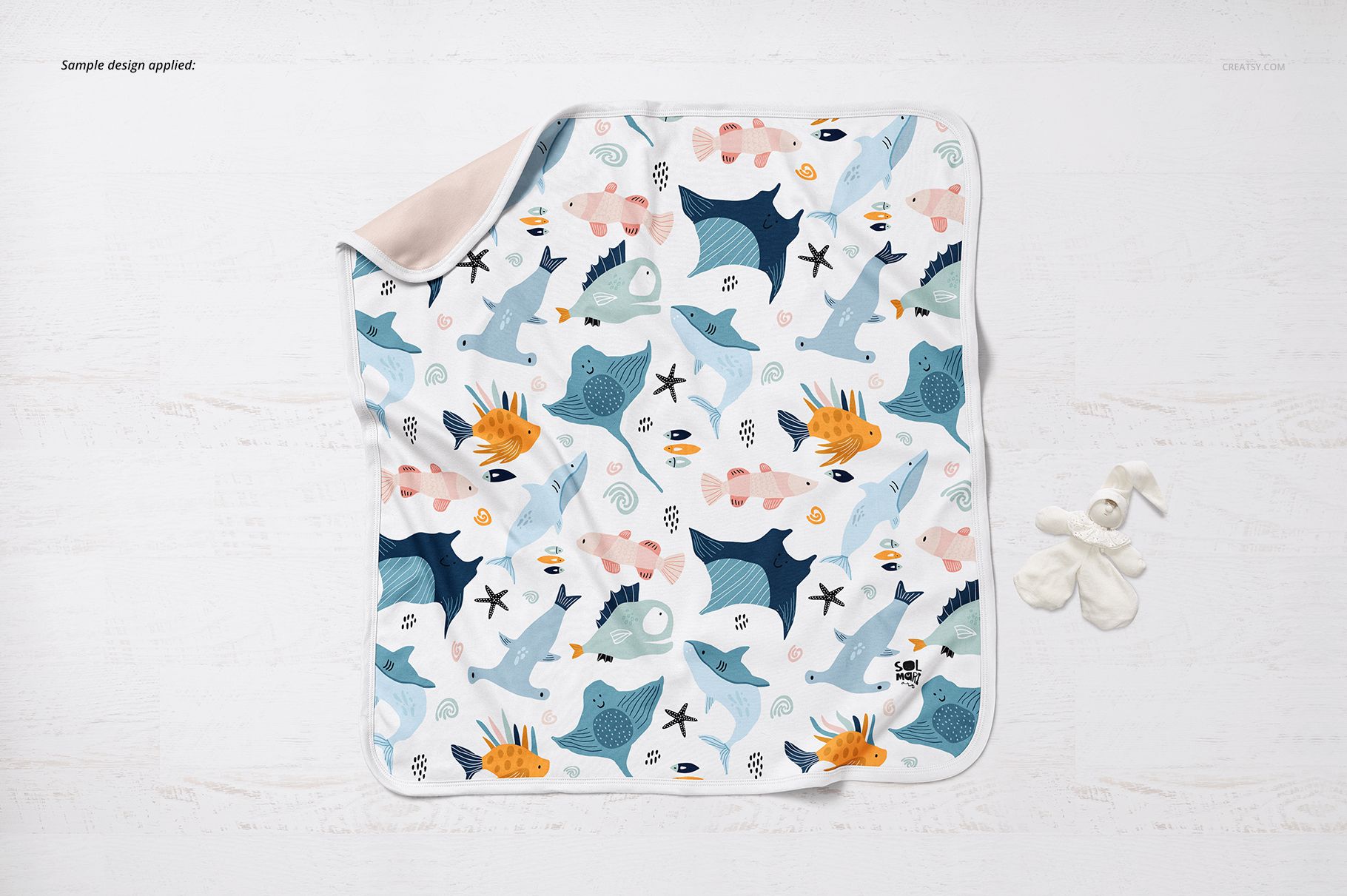 Square cotton baby blanket mockup featuring playful ocean creatures and soft pastel colors, viewed from above.