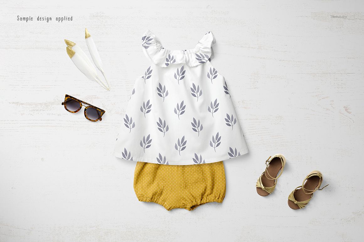 Baby summer set mockup featuring a white top with gray leaf pattern and mustard yellow shorts, flat lay view.