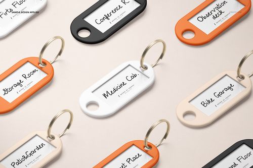 Front view of key tag mockup set featuring orange, white, and black tags with handwritten labels on a neutral background.
