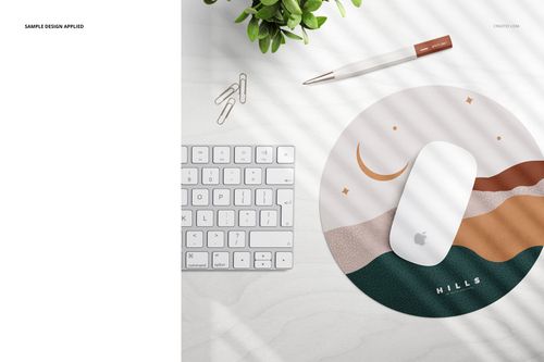 Top view of a circular mouse pad mockup featuring a stylized hills pattern, surrounded by desktop accessories.
