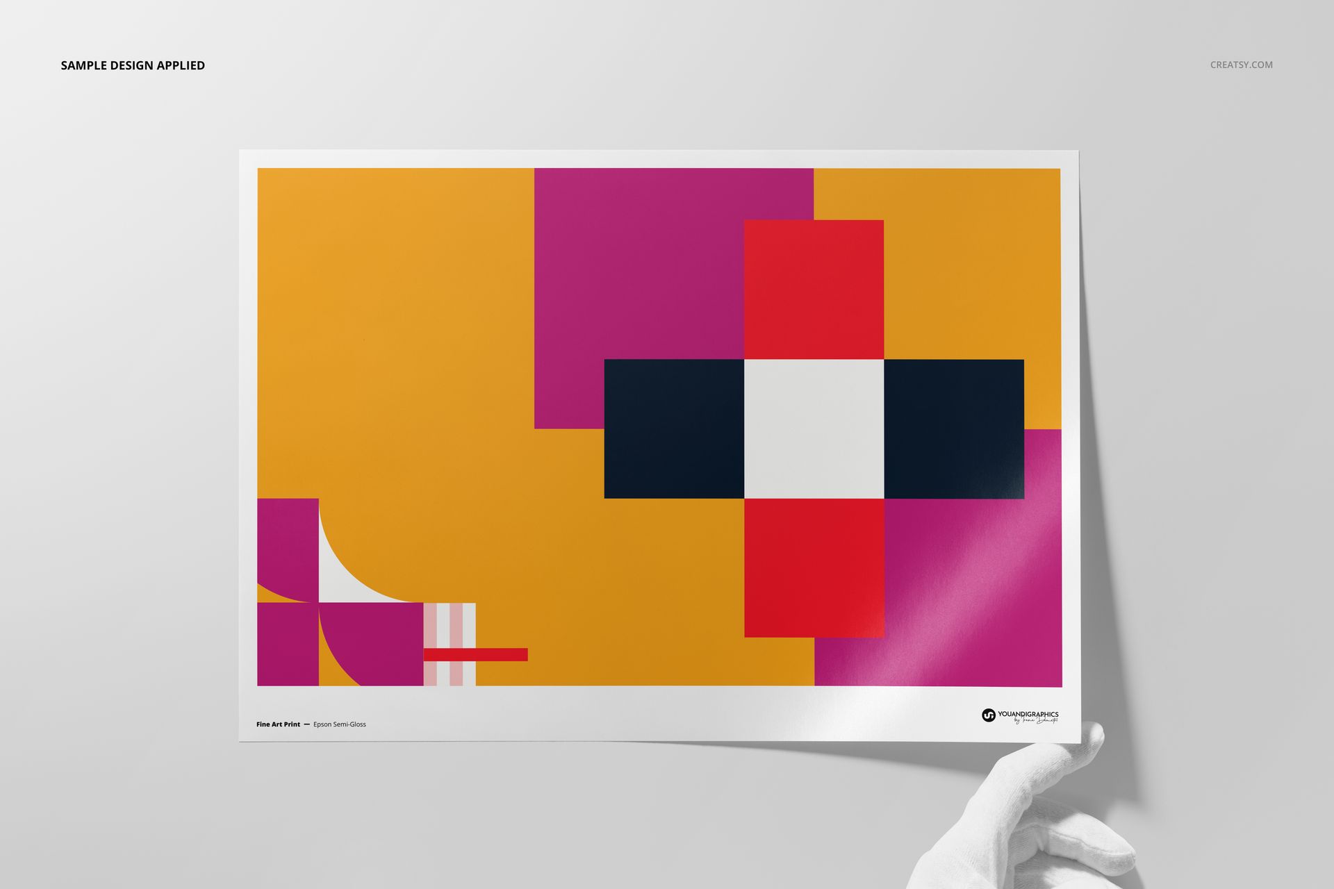 A3 fine art print mockup featuring a geometric abstract design in magenta, yellow, black, and white, held by a gloved hand.