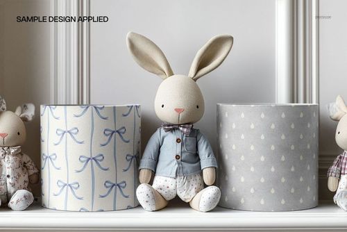 PSD mockup of kids room drum lampshades, patterned with blue bows and gray dots, plush bunny seated in the middle.
