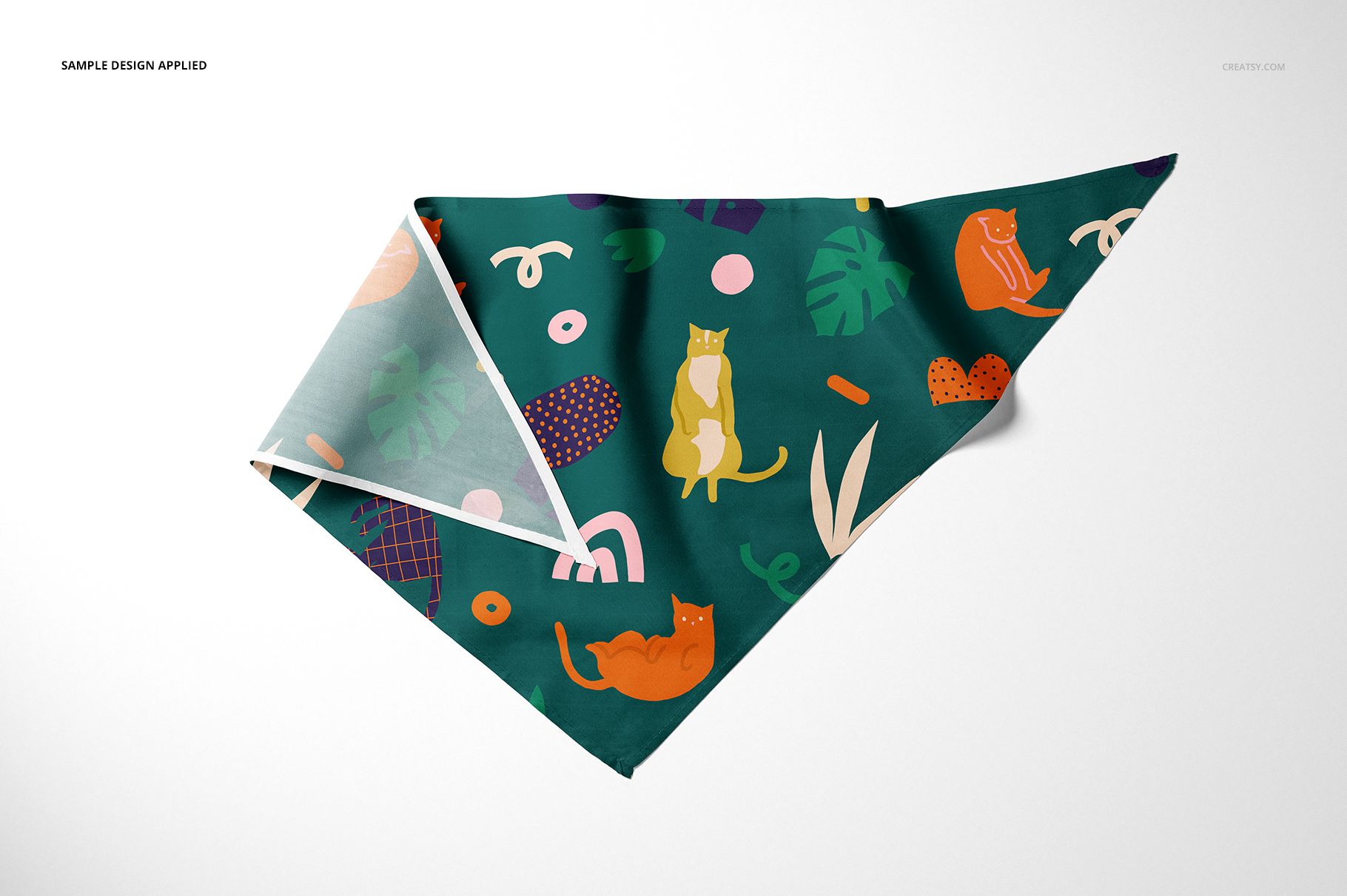 Triangular pet bandana mockup with green background, featuring playful cat illustrations and abstract shapes, front view.
