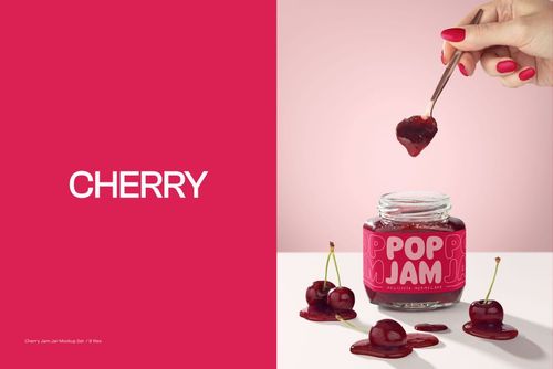 Cherry jam jar mockup with vibrant pink background, spilled jam, loose cherries, and hand scooping jam with a spoon.