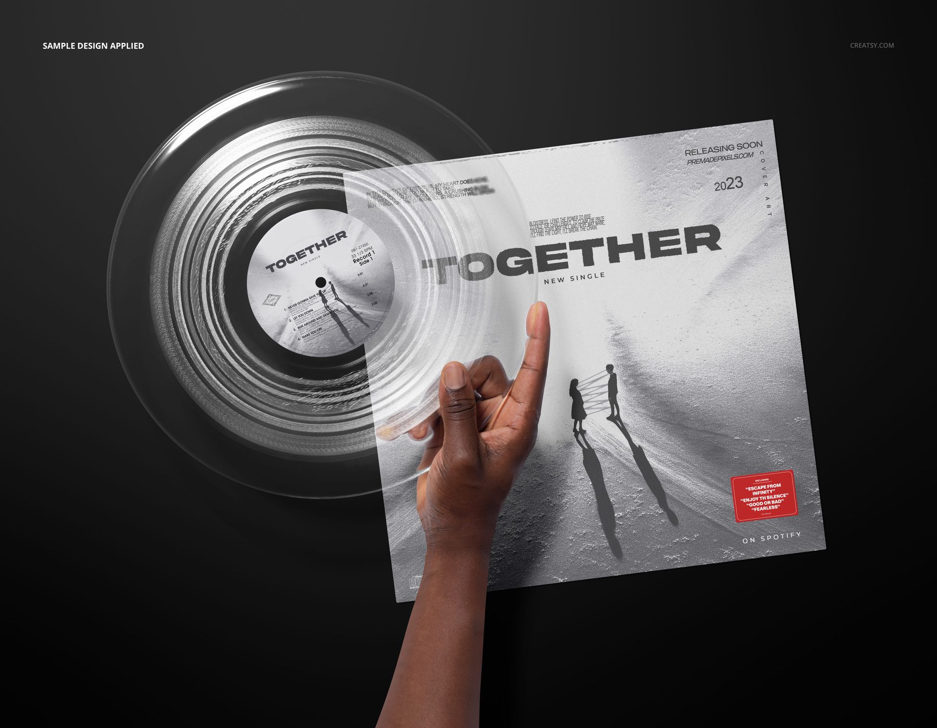 PSD mockup showing a clear vinyl record in hand with an album cover displaying modern monochrome artwork.