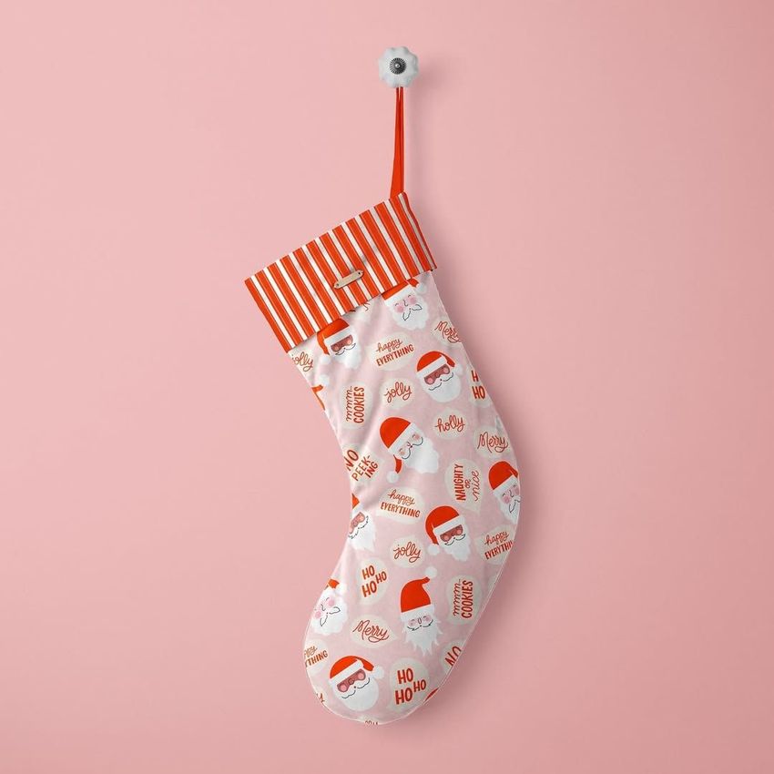 Velvet Christmas stocking mockup featuring a red and white Santa pattern with festive text on a soft pink background.