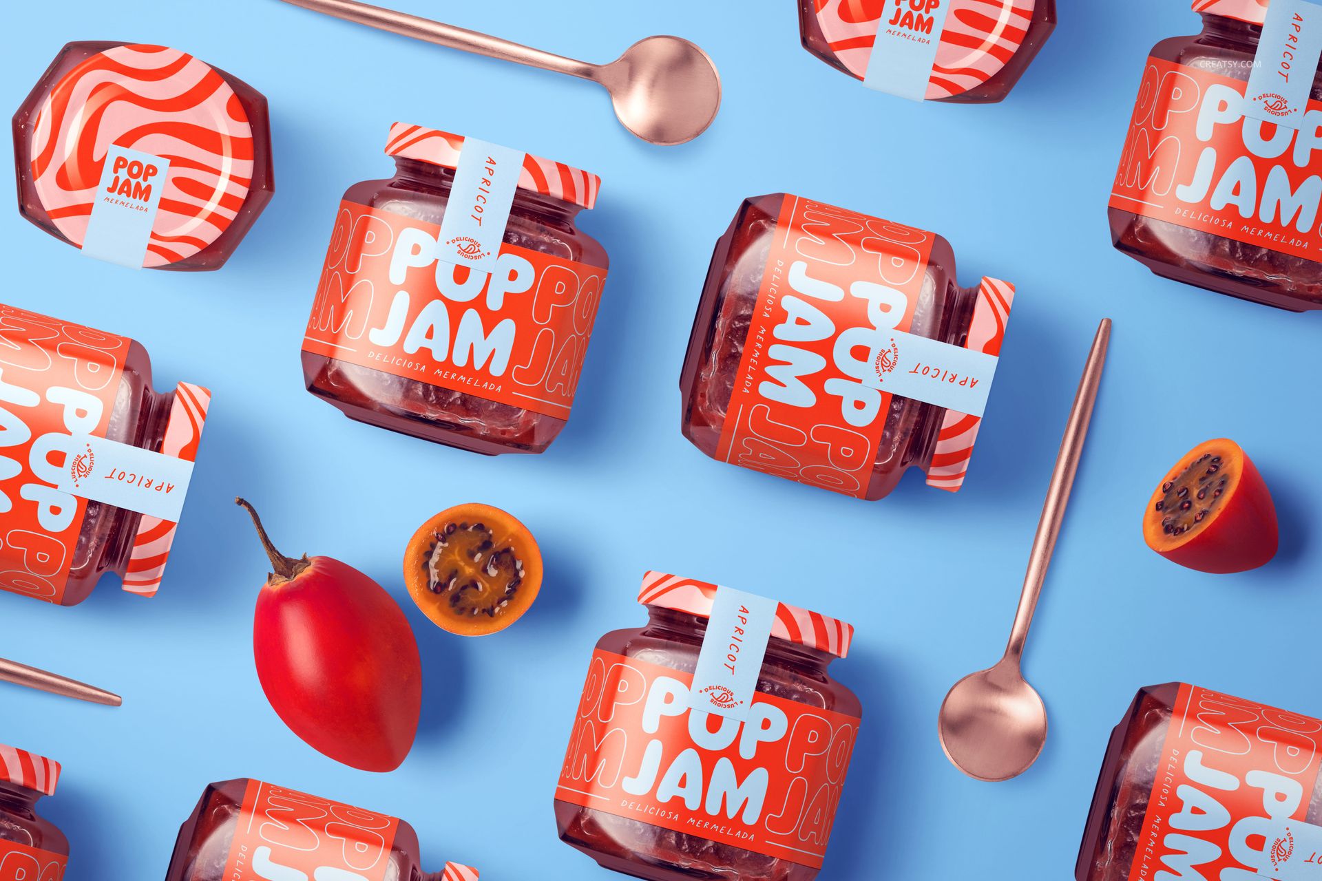 PSD mockup showing jam jars with vibrant orange packaging, placed among spoons and sliced fruit on a light blue tabletop.