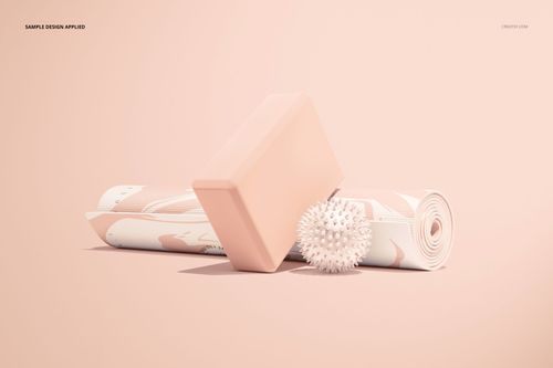 Yoga mat mockup featuring a rolled mat with soft pink and beige design, accompanied by a block and textured massage ball.