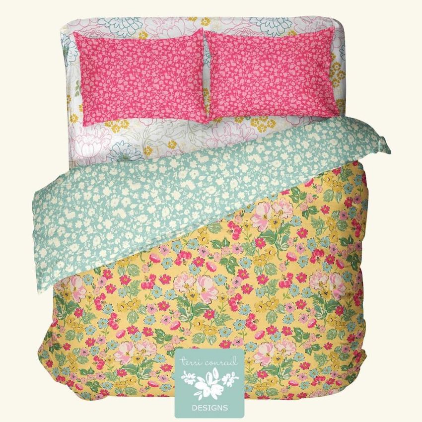 Double bed bedding mockup featuring a floral duvet in yellow and pink, with patterned pillows and a folded green cover.