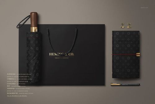 Top view of men's fashion mockup set featuring a black umbrella, shopping bag, notebook, and pen arranged neatly.