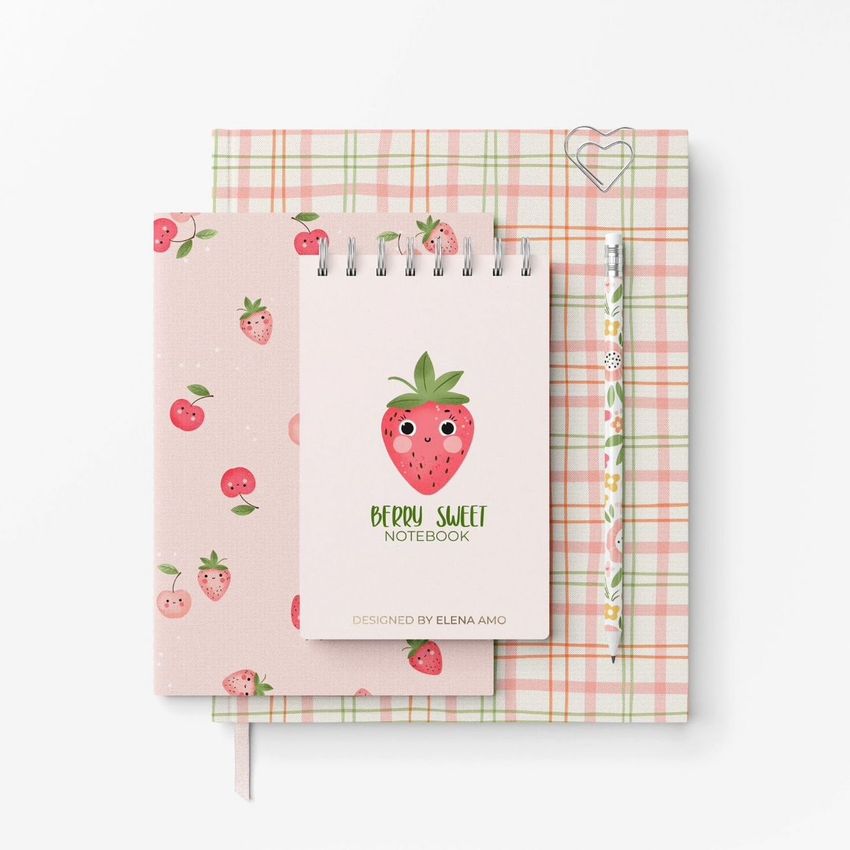 Stationery mockup featuring a spiral notebook with a cute strawberry illustration, a pencil, and two patterned notebooks on a white background.