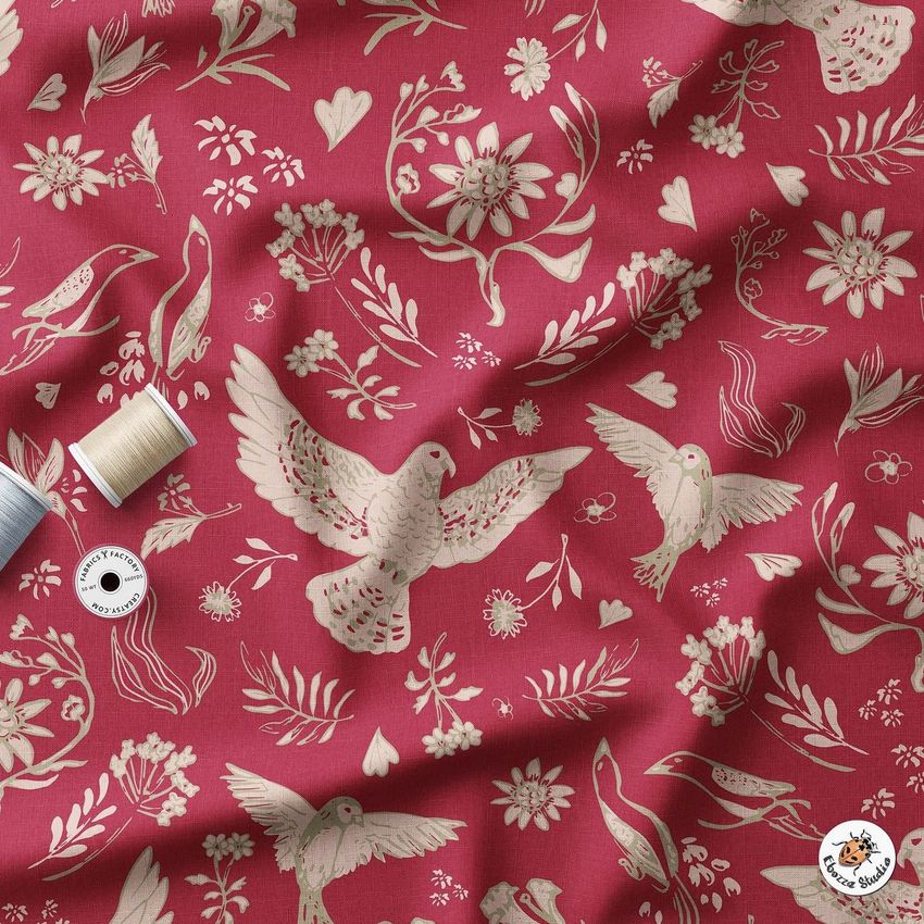 Wrinkled fabric mockup featuring a red textile with cream-colored bird and floral illustrations, viewed from above.
