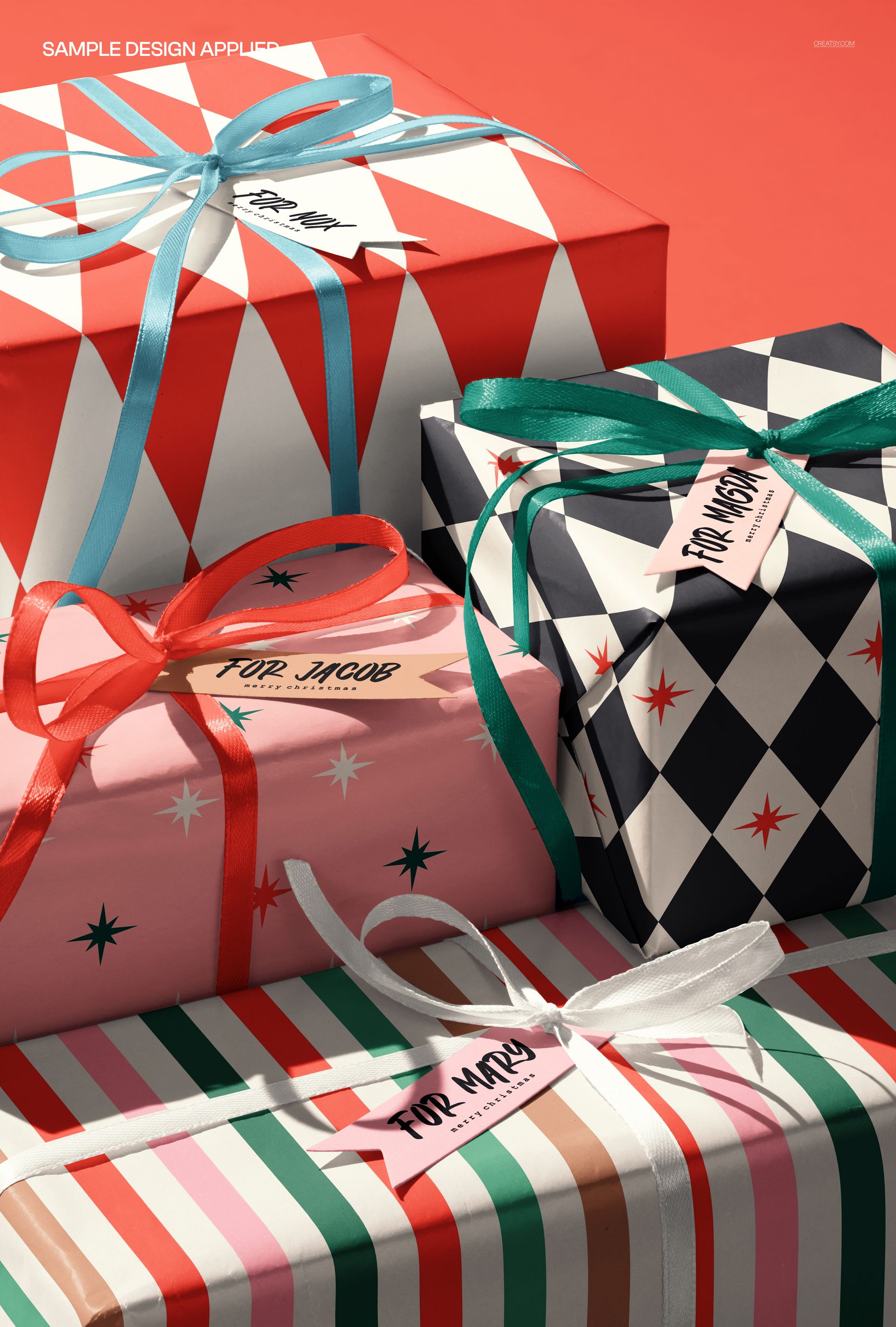 PSD mockup of stacked gift boxes featuring bold patterns, ribbons, and personalized labels on a red surface.