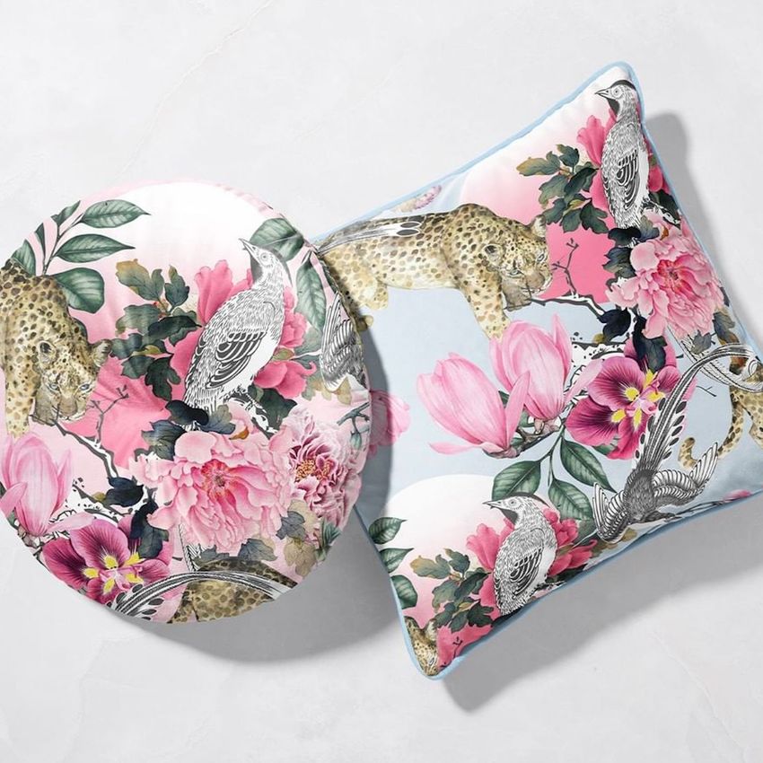 Square and round velvet cushion mockup with piping, featuring a floral and animal pattern in pink, green, and beige hues.