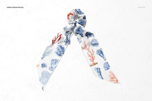 Fashion accessory mockup showing a scrunchie scarf with sea-inspired blue and red coral motifs on white fabric.