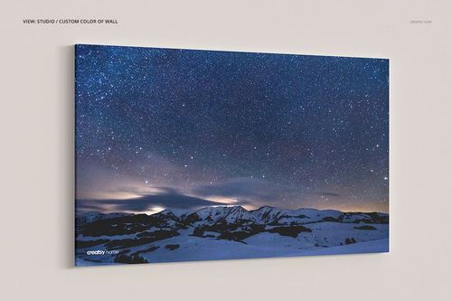 Rectangular canvas print mockup with a starry night sky and snowy mountain landscape, front perspective view.