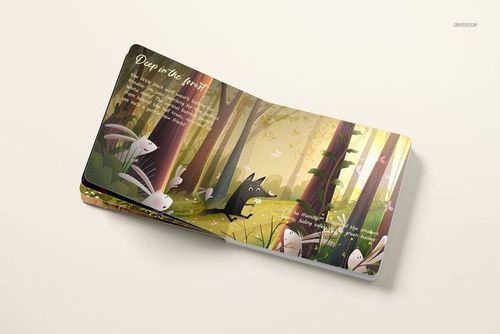 Cardboard baby book mockup showing colorful woodland illustration with greenery, animals, and soft lighting from above.