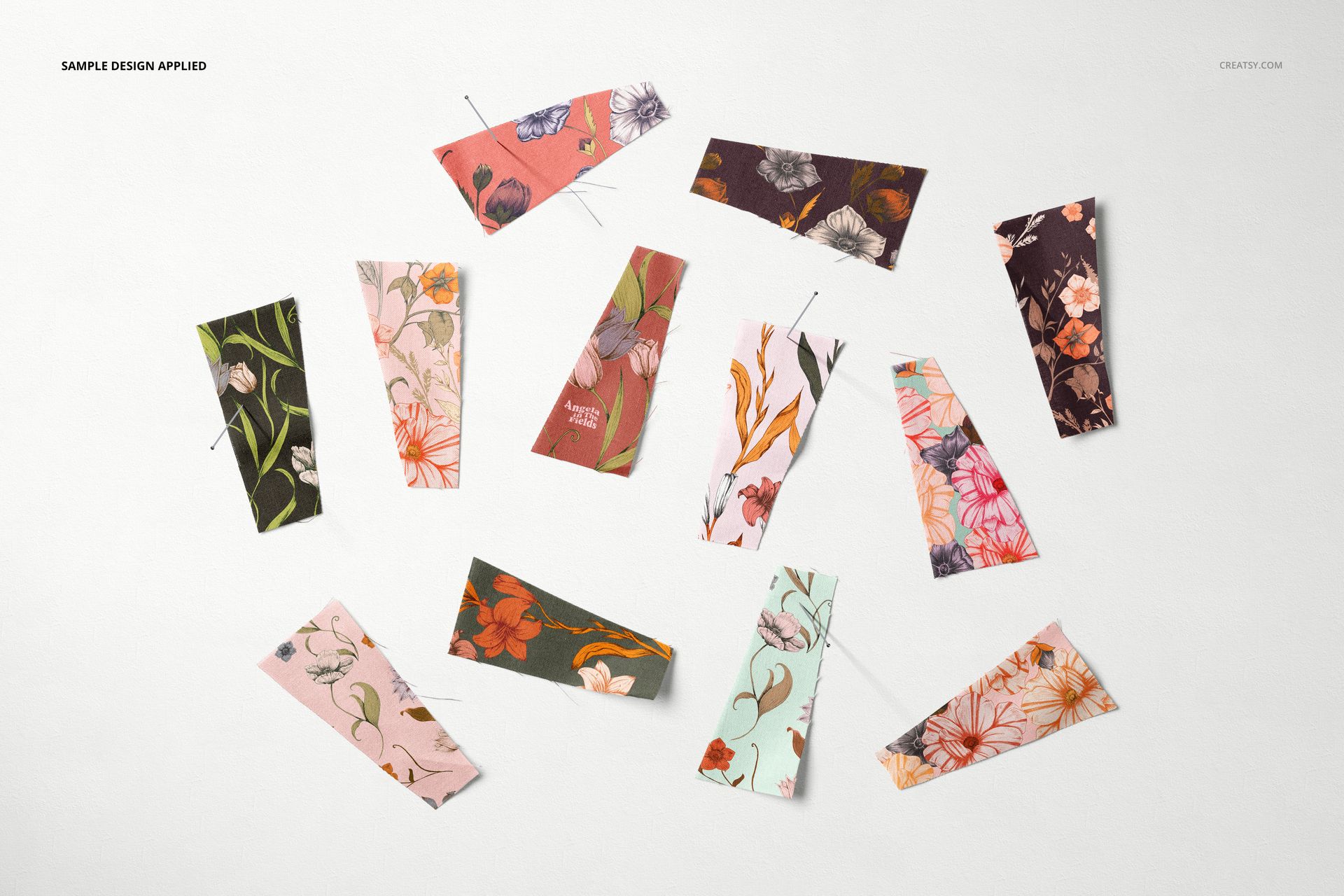 Multiple fabric swatches in diverse colors and floral prints displayed flat, shown in a textile PSD mockup layout.