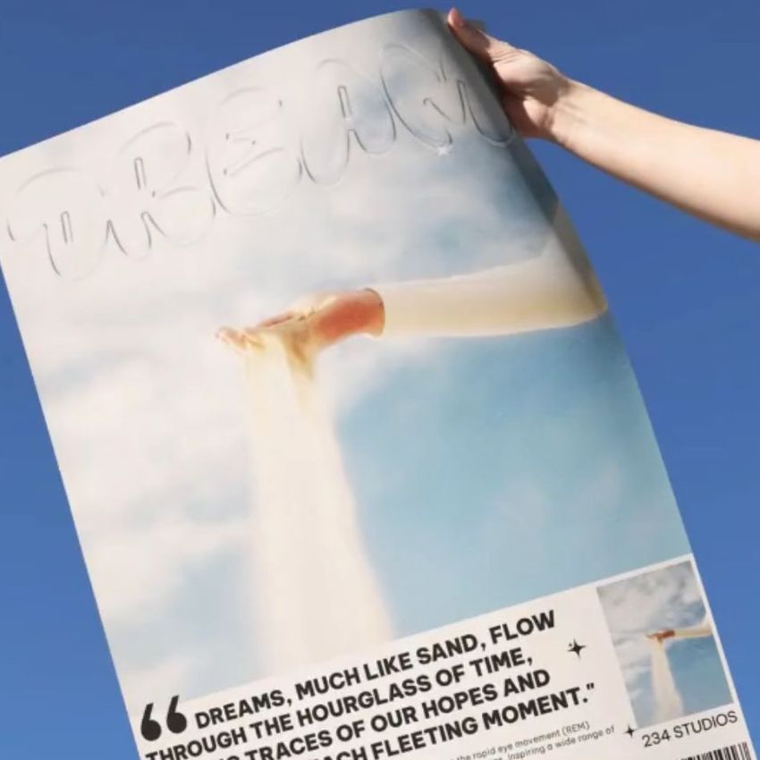 Hand holding a skyline poster mockup against a clear blue sky, featuring an artistic image of feet and sand with text overlay.