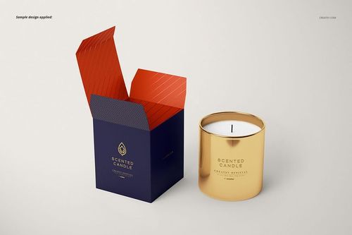 Front view of a classic metallic candle mockup with a gold vessel and an open dark blue box with red interior accents.