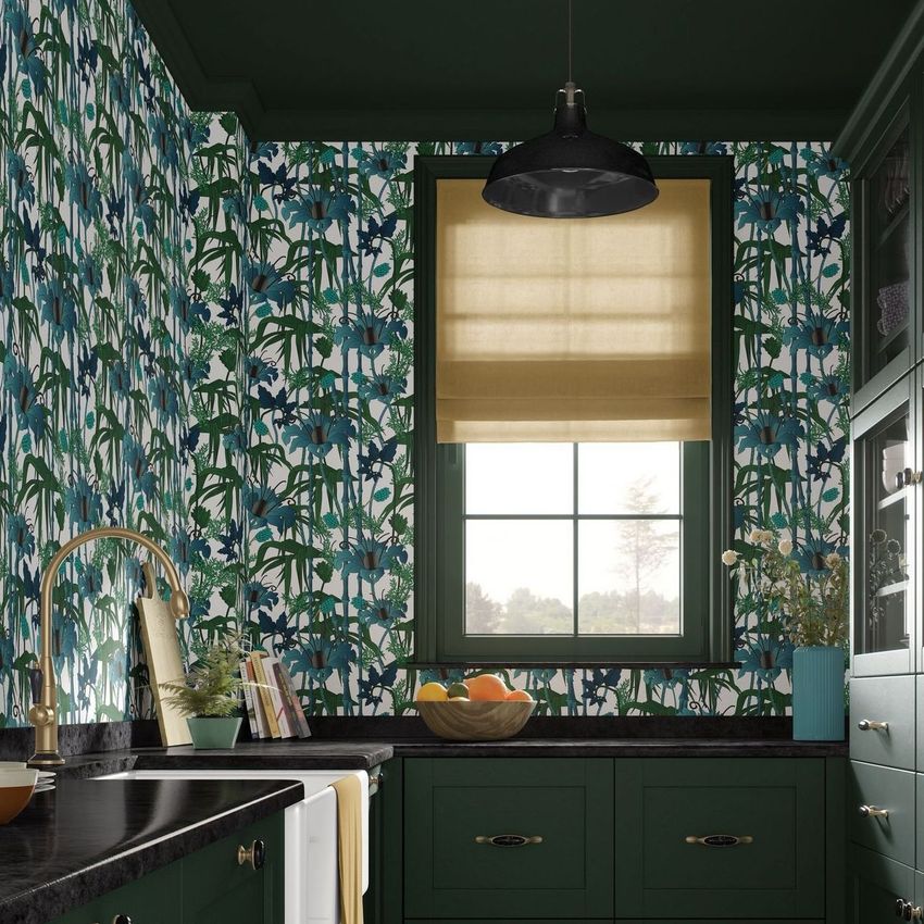 French kitchen design mockup showing a window with a beige shade, green cabinets, and blue floral wallpaper on the walls.